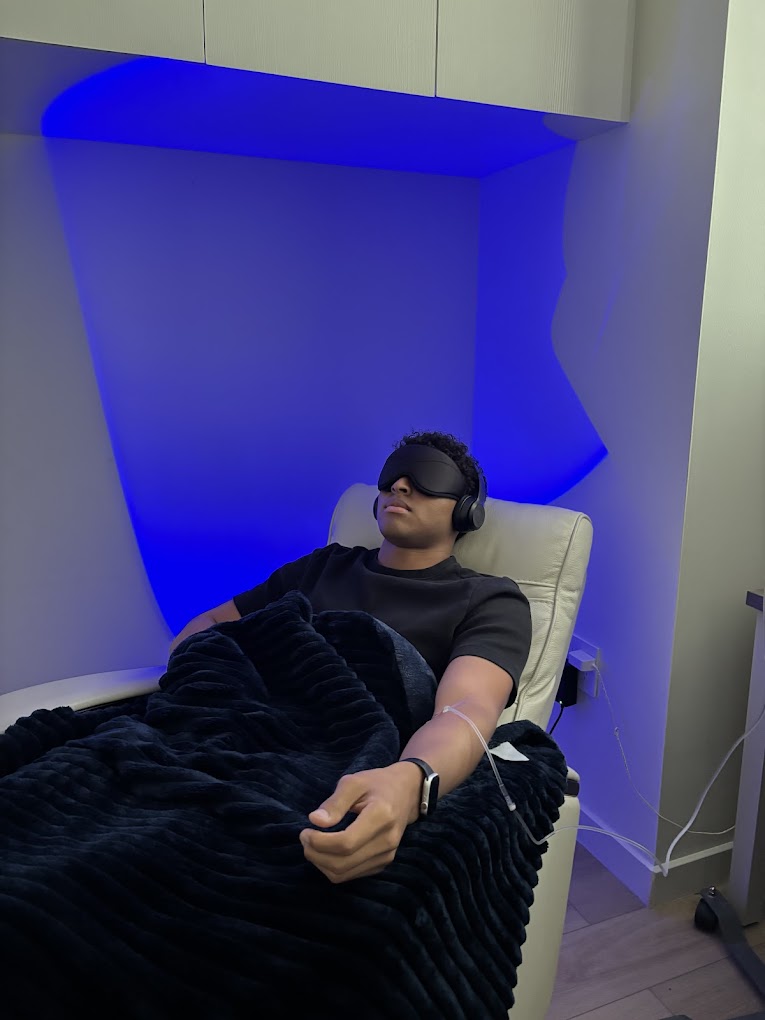 A patient receiving an IV ketamine infusion in a calm, private, monitored treatment room